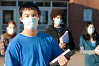 Shot for stock photography. Four teens of various ethnic backgrounds in front of a school wearing masks to protect against germs holding books.

Click to enlarge photo